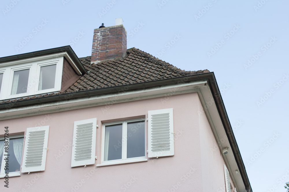 Dach eines Wohnhauses vor blauem Himmel