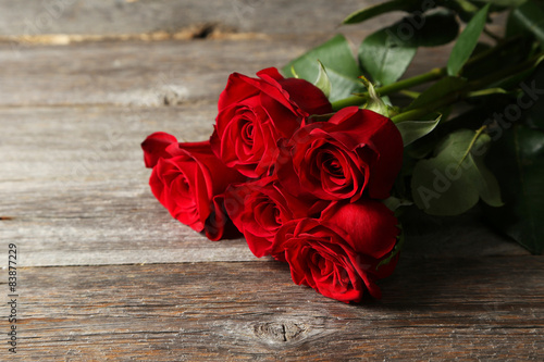 Fototapeta Naklejka Na Ścianę i Meble -  Five fresh red roses on grey wooden background
