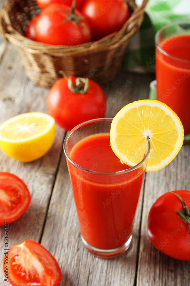 Fresh red tomatoes in basket and juice in glass Fresh red tomatoes in basket and juice in glass
