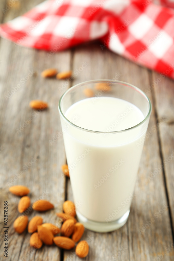 Glass of milk with almonds on grey wooden background Glass of milk with almonds on grey wooden background