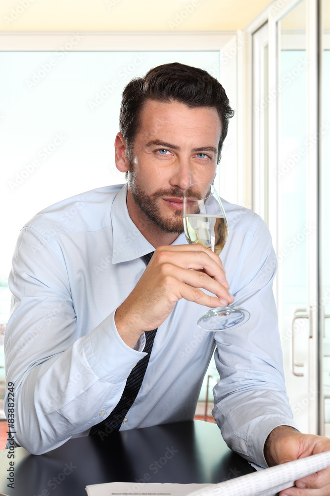 handsome man drinking a glass of sparkling wine white, in bar