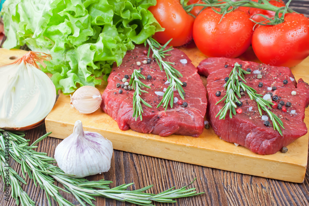 Raw beef steak with vegetables and spices Raw beef steak with vegetables and spices