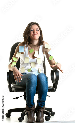 Beautiful young woman at work with many post-its on her.