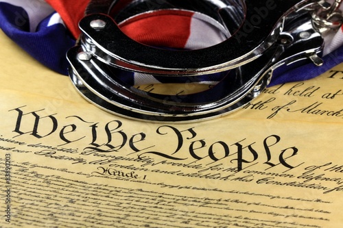 Handcuffs and American flag on US Constitution-Fourth Amendment photo