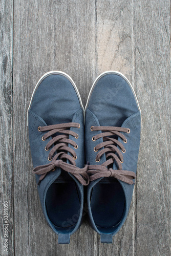 Blue Sneakers on Old Wood Background 