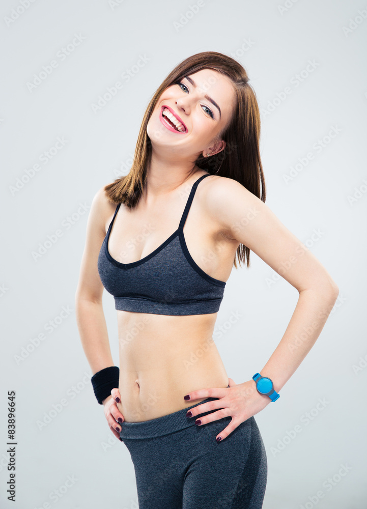 Laughing fitness woman standing over gray background