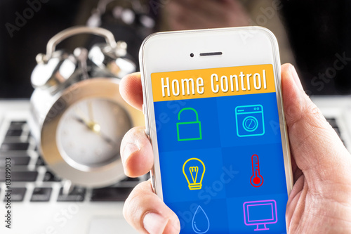 Hand holding smart phone with home control application with cloc photo