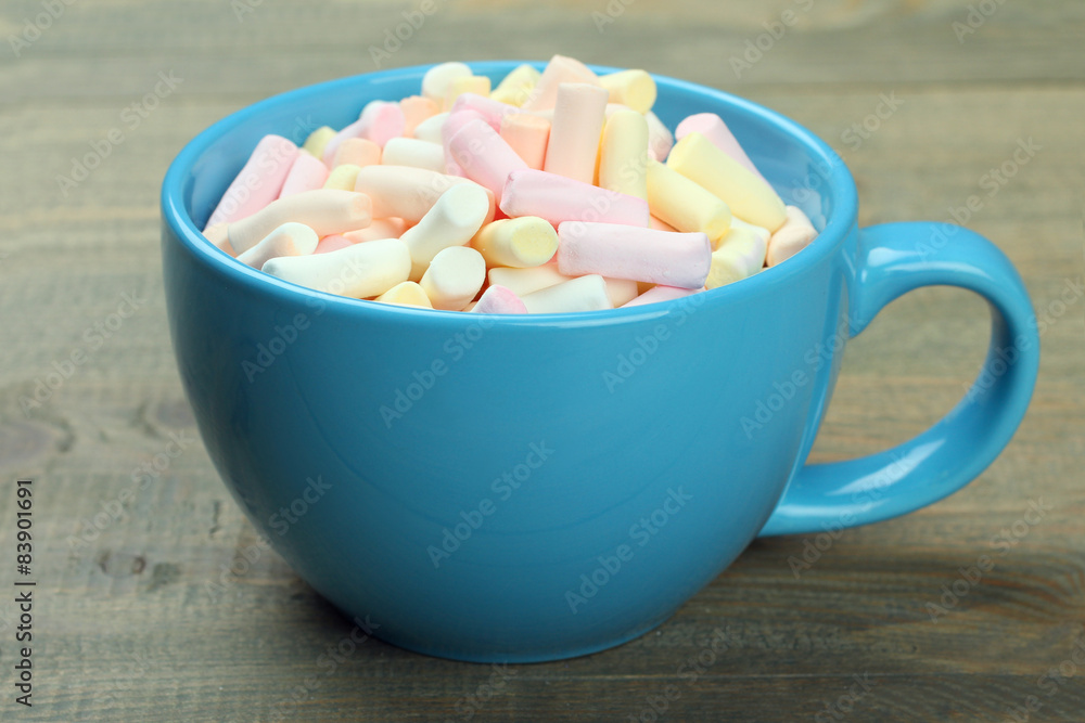 Marshmallow in a blue cup on a wooden background Marshmallow in a blue cup on a wooden background