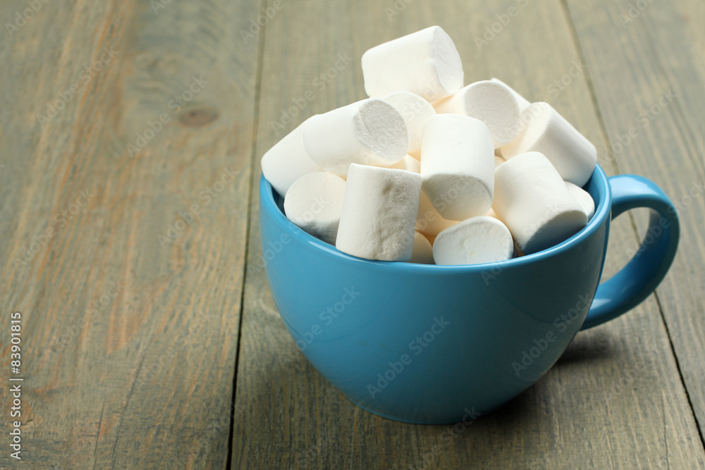 Marshmallow in a blue cup on a wooden background Marshmallow in a blue cup on a wooden background