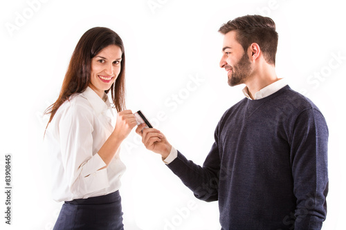 casual young man giving a credit card to young woman