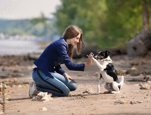 Young woman with her dog on the beach