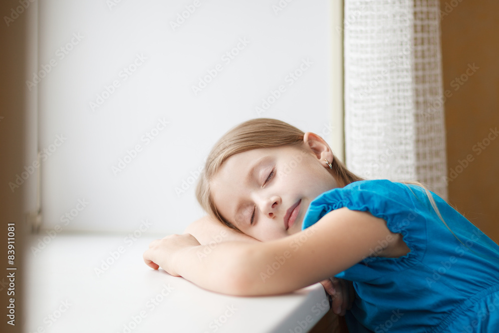 Little girl sleeping on windowsill