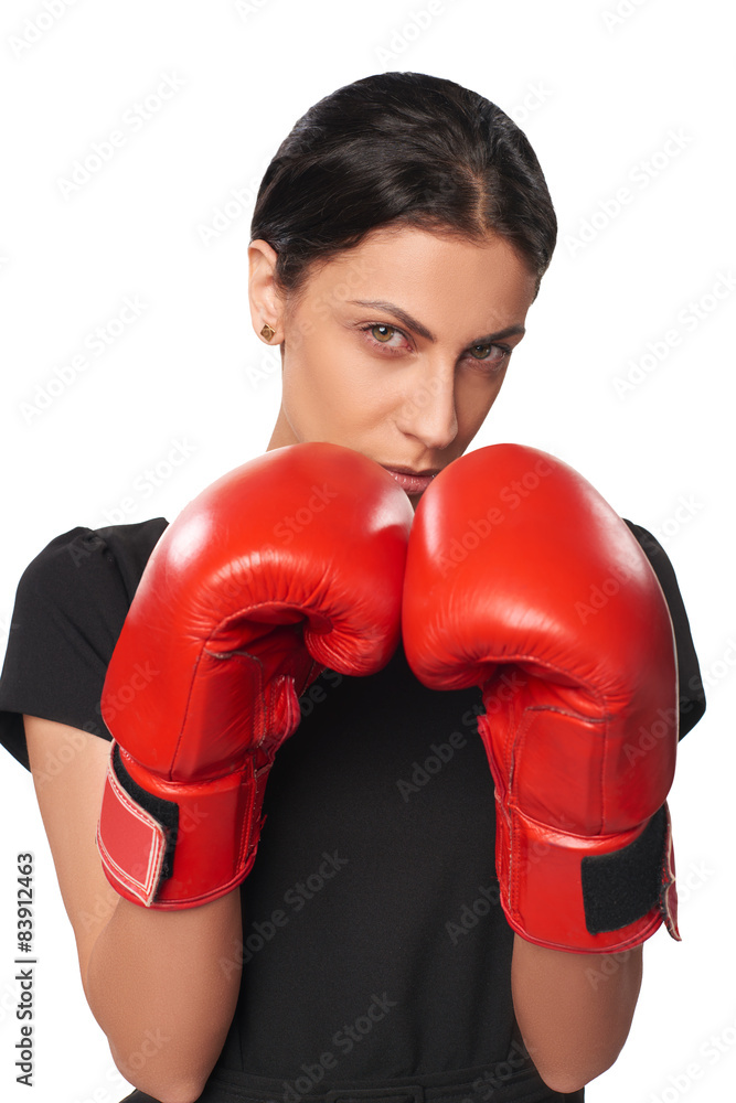 Serious business woman wearing boxing gloves Serious business woman wearing boxing gloves