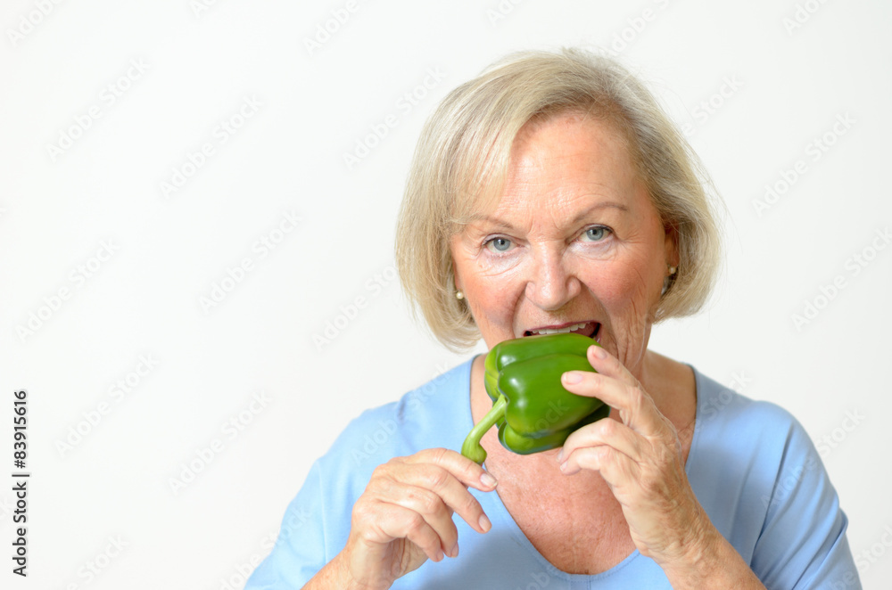 Seniorin riecht an einer Paprika Seniorin riecht an einer Paprika