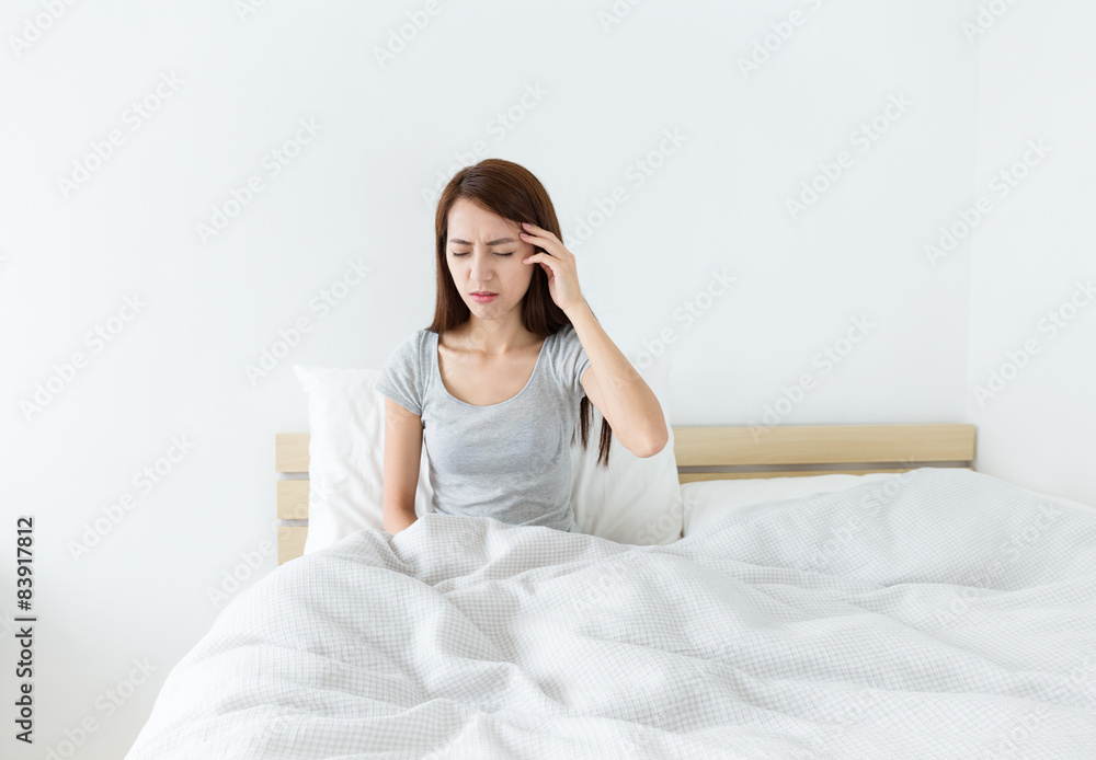 Woman feeling headache and sitting on the bed Woman feeling headache and sitting on the bed