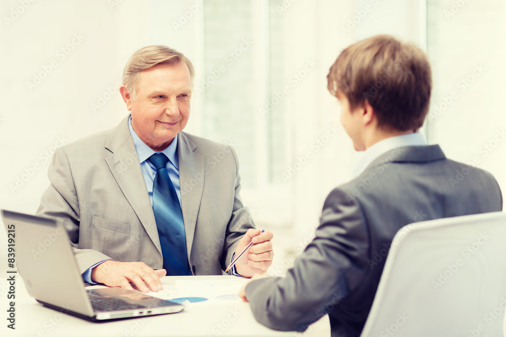 older man and young man having meeting in office older man and young man having meeting in office