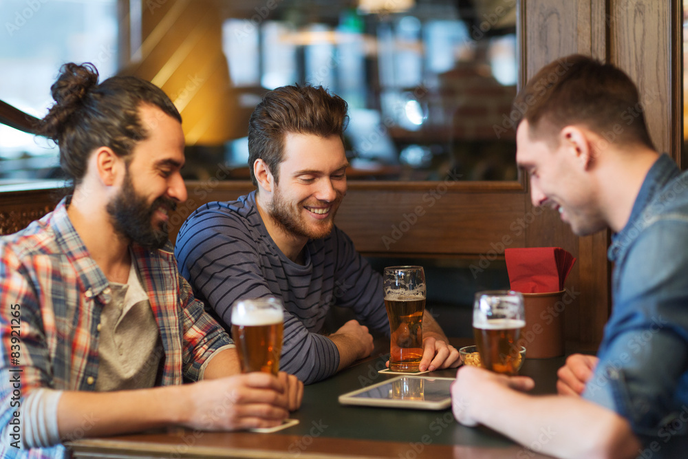 male friends with tablet pc drinking beer at bar male friends with tablet pc drinking beer at bar