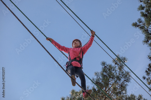 Girl climbing in adventure park , rope park 