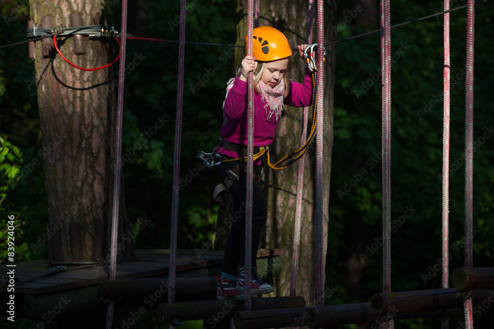 Girl climbing in adventure park , rope park  