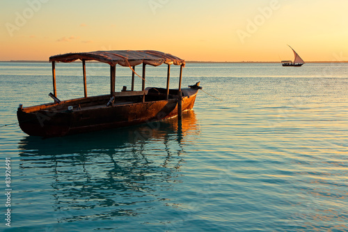 Wooden boat on water at sunset, Zanzibar island