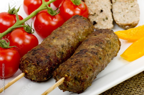 Barbecued Lamb Kebabs with vine tomatoes and yellow peppers.