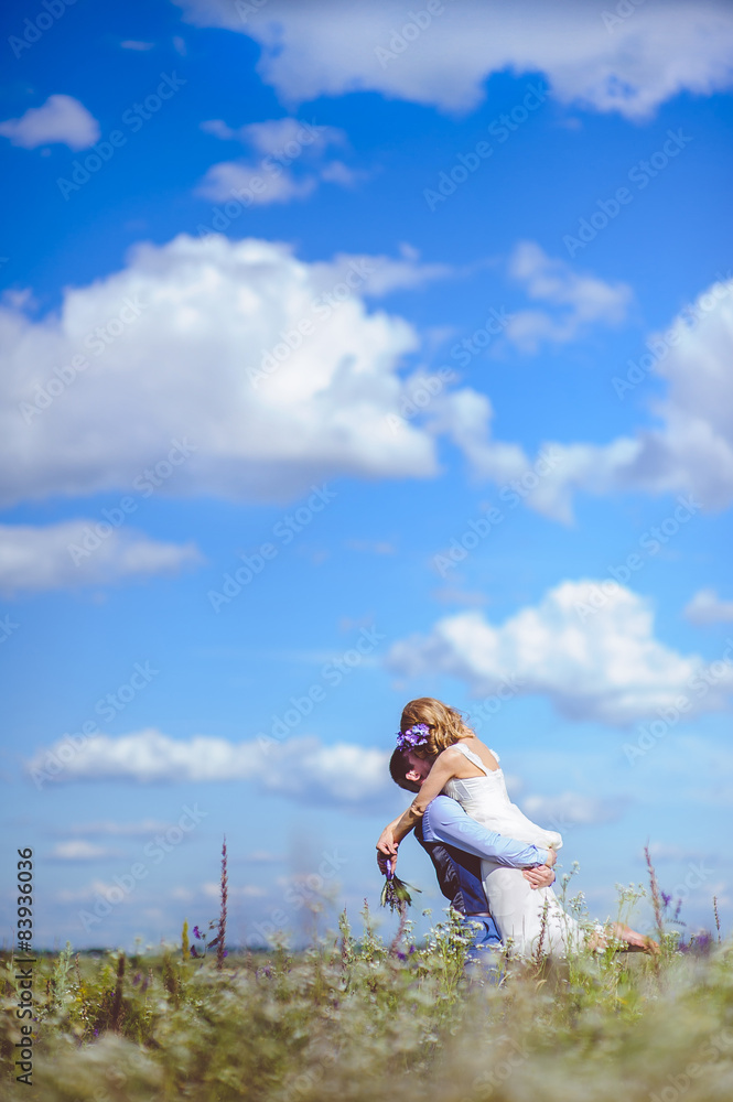 A young newlywed couple embracing on the field A young newlywed couple embracing on the field