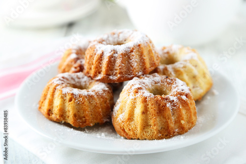 Bundt cakes on plate on white wooden background