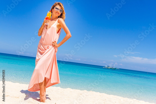 young happy beautiful woman with bright tropical cocktail on blu