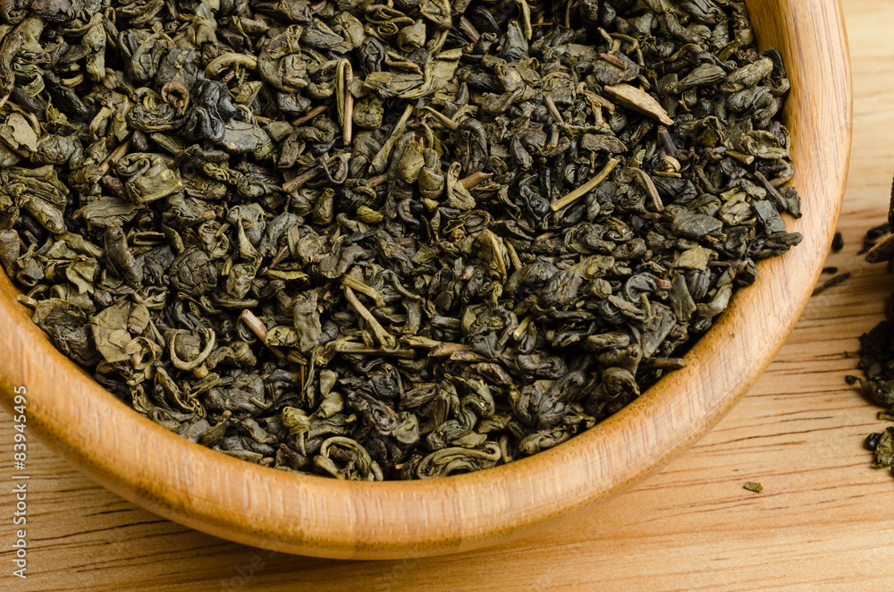 green tea, dried leaves, on wooden background green tea, dried leaves, on wooden background