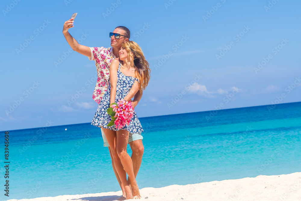 Vacation couple on beach taking pictures with camera phone. Roma Vacation couple on beach taking pictures with camera phone. Roma