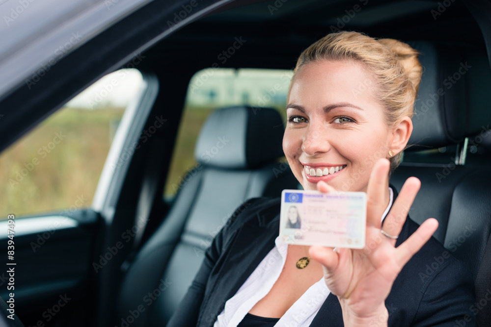 Frau zeigt stolz ihren Führerschein aus dem Auto - obrazy, fototapety, plakaty 
