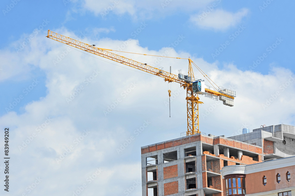 Crane and building construction site against blue sky Crane and building construction site against blue sky