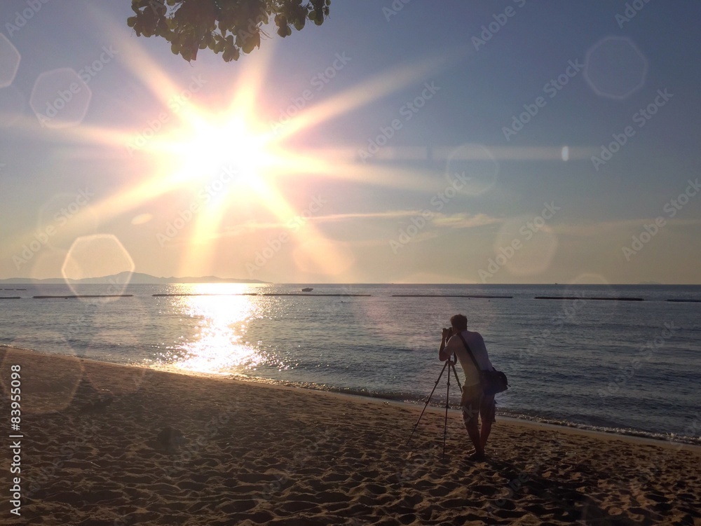 photographer working with big sun. 