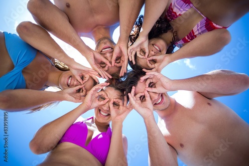 Happy friends standing in circle doing funny face