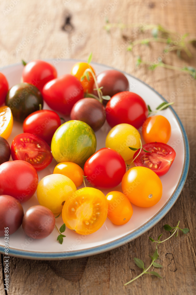 colorful tomatoes in plate on wooden background colorful tomatoes in plate on wooden background