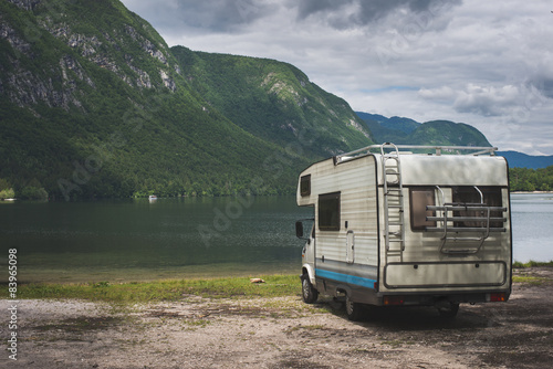 Camper van parked on a beach, mountain range landscape