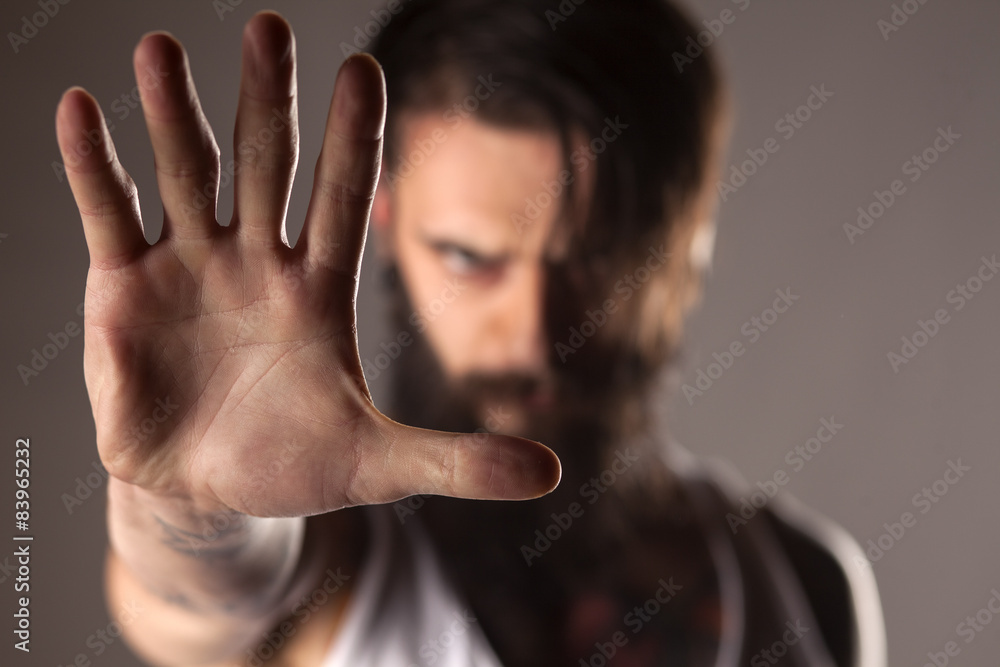 a young man with a beard shows the stop hand a young man with a beard shows the stop hand