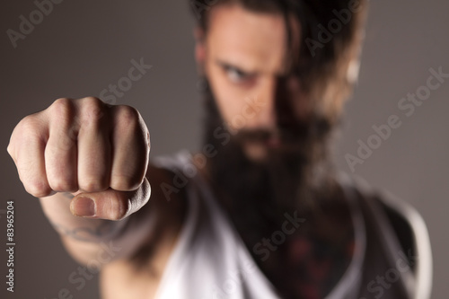 a young man with a beard showing fist