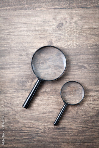 Magnifying glass on wooden table, Search and discover symbol