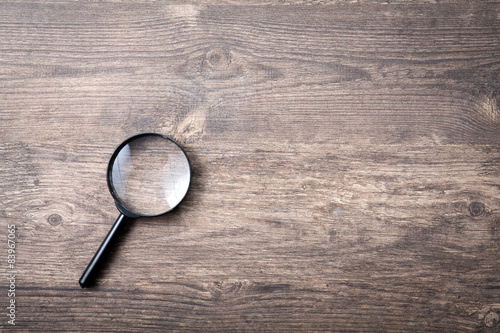 Magnifying glass on wooden table, Search and discover symbol photo