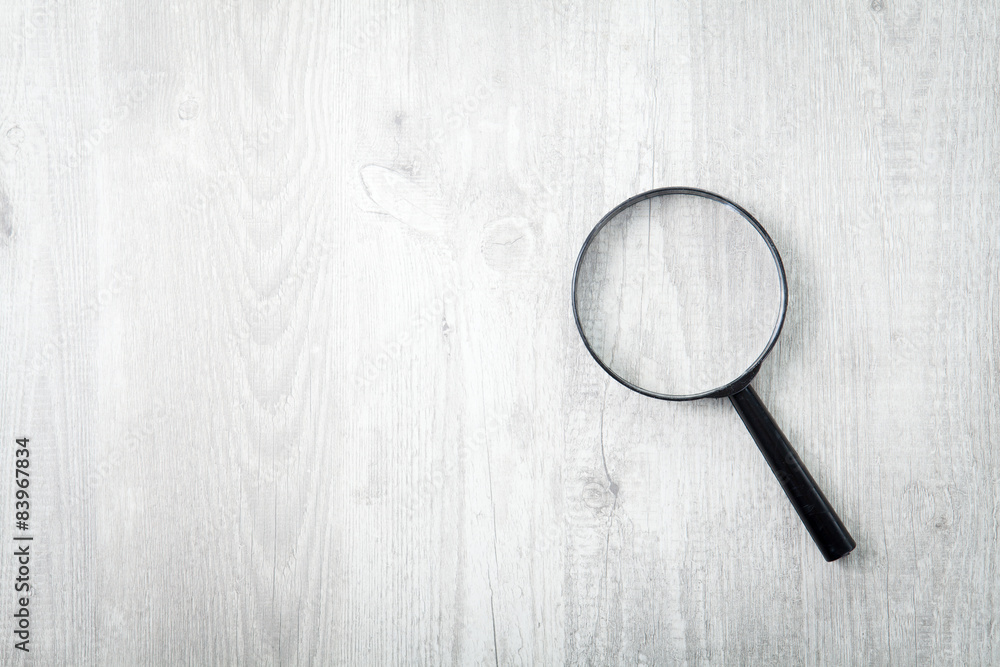 Magnifying glass on wooden table, Search and discover symbol