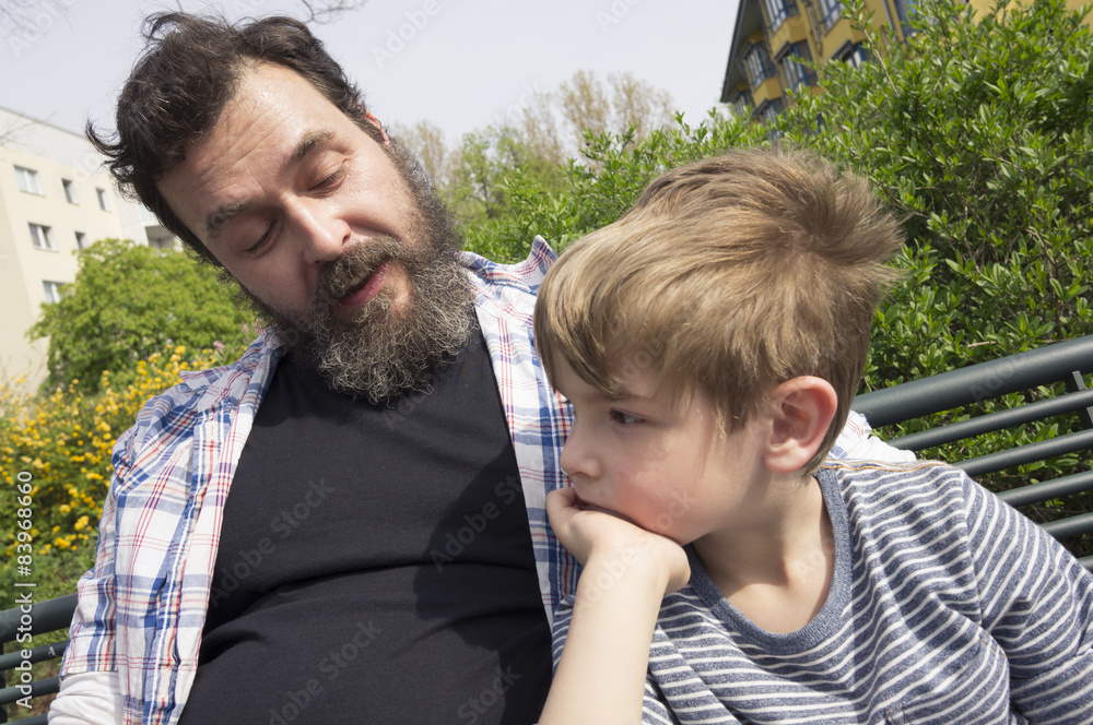 Vater und Sohn auf Parkbank in Wohnsiedlung. Berlin. Vater und Sohn auf Parkbank in Wohnsiedlung. Berlin.