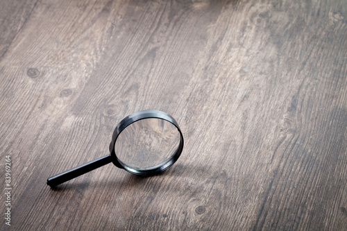Magnifying glass on wooden table, Search and discover symbol