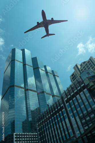 Airplane in the sky with modern buildings