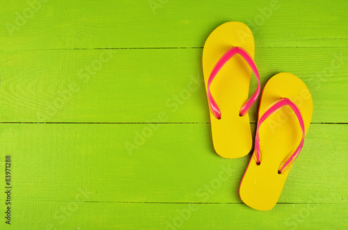 Flip Flops Yellow on green wooden background