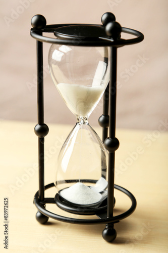 Black hourglass on wooden background