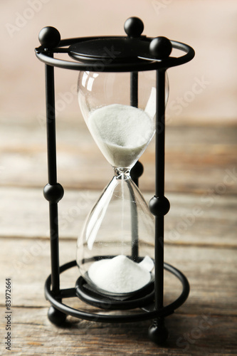 Black hourglass on grey wooden background