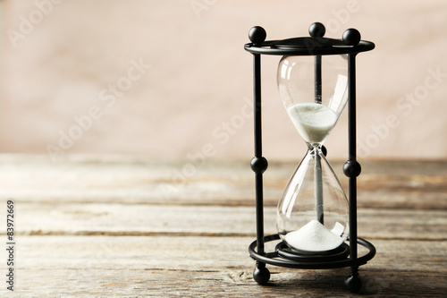 Black hourglass on grey wooden background