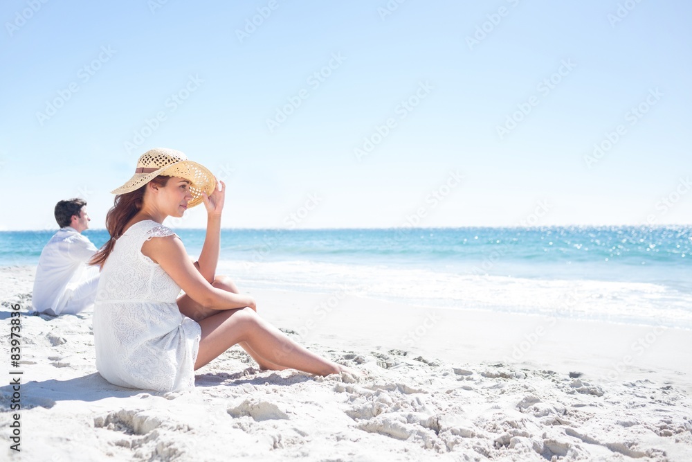Brunette sitting in the sand and looking at the sea Brunette sitting in the sand and looking at the sea