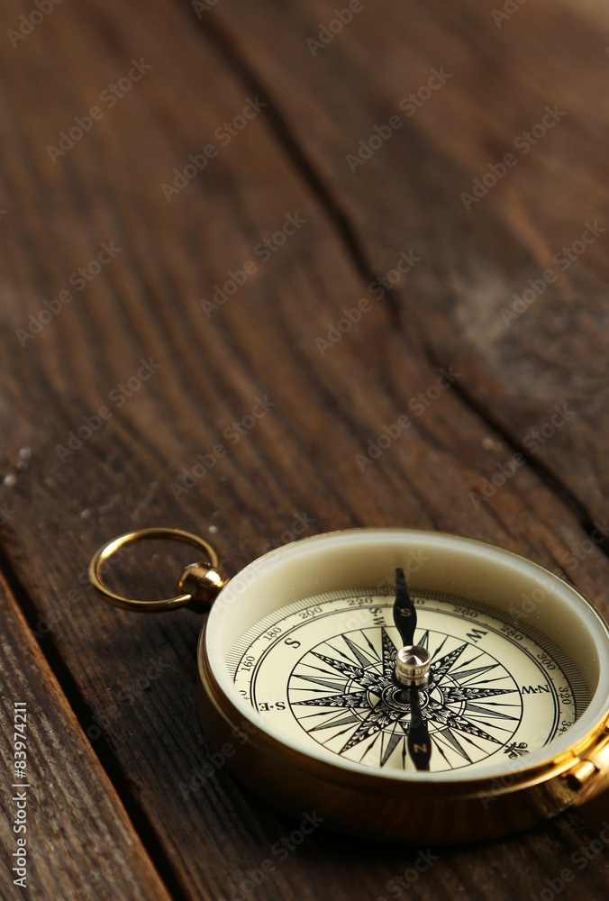 Compass on brown wooden background Compass on brown wooden background